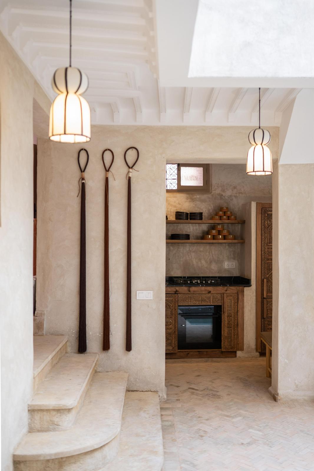 Kasbah Lover kitchen with tadelakt walls, carved wooden cabinetry and lantern pendants