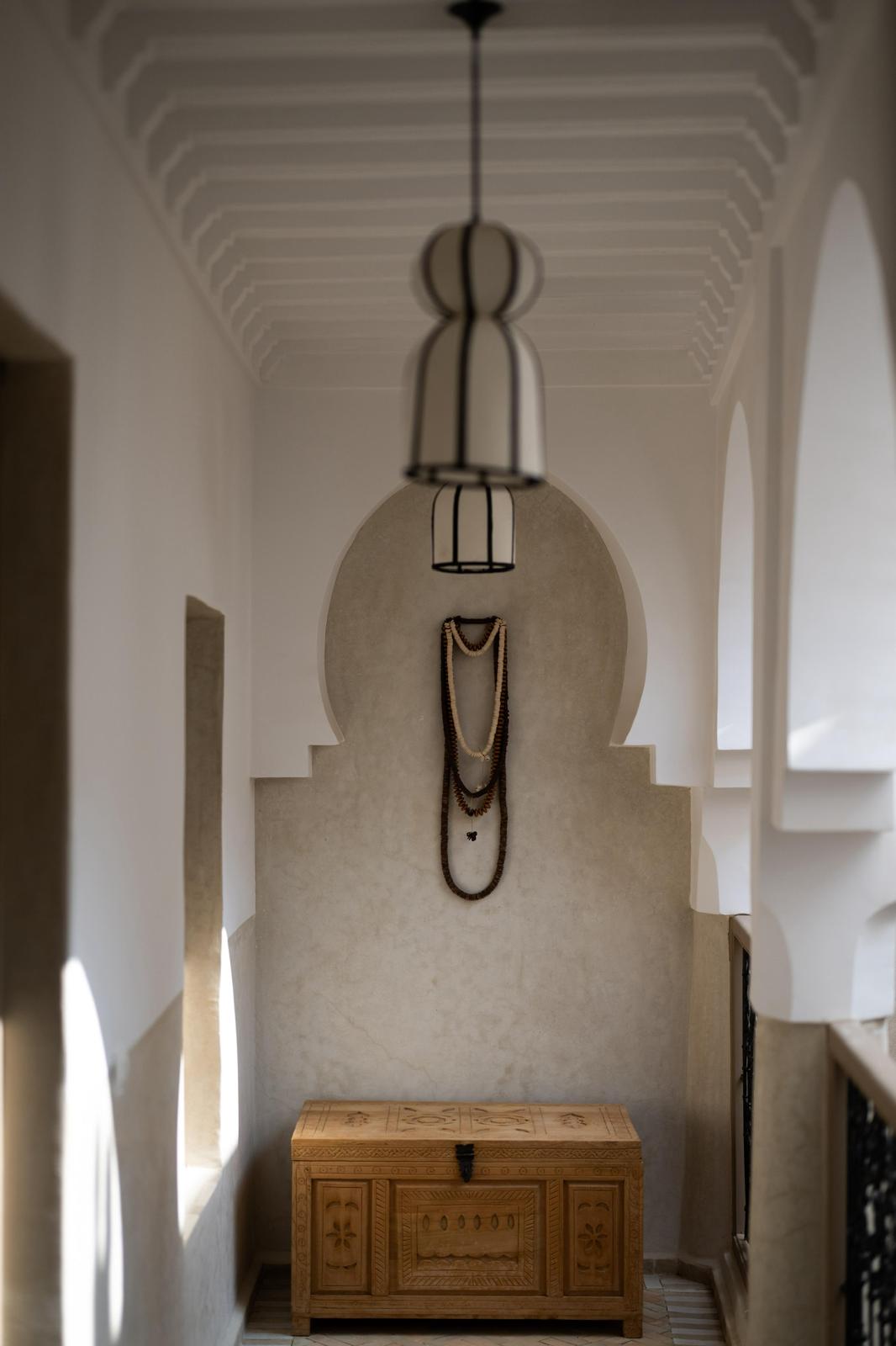 Kasbah Lover stairway landing with an arched niche, a carved wooden chest and a hanging lantern