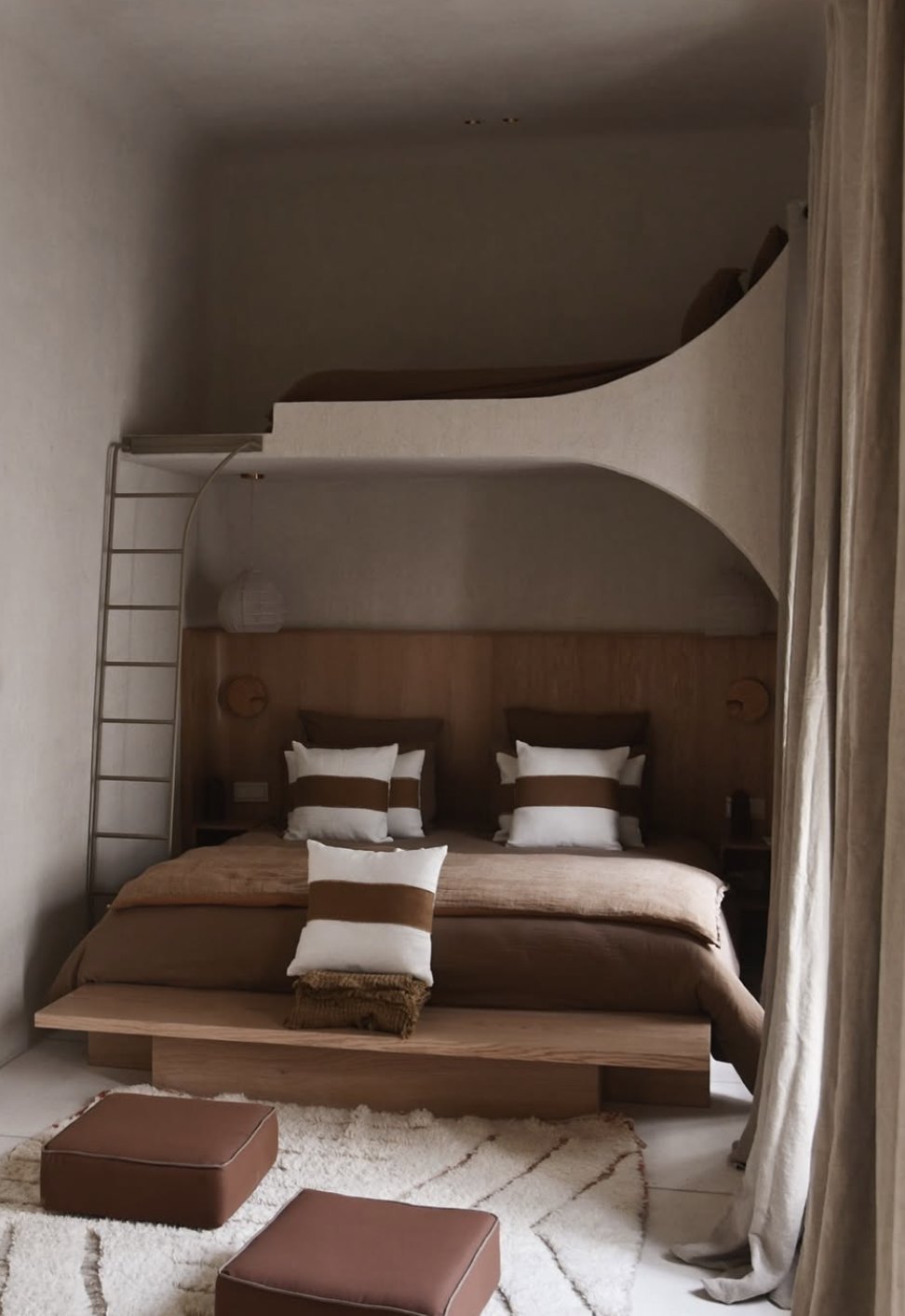 Riad Japandi bedroom with a sculpted plaster bunk alcove, cocoa linens and leather poufs on a Berber rug